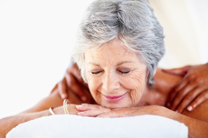 Closeup of senior woman receiving a shoulder massage in a spa center